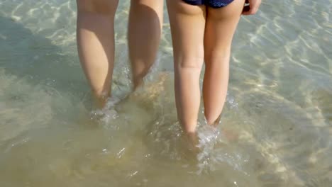 Mother-and-kid-walking-into-pure-sea-water