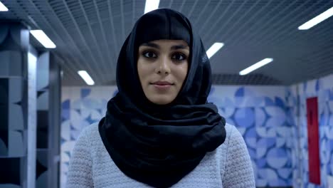 Young-muslim-woman-in-hijab-is-standing-in-underpass,-watching-at-camera,-religion-concept