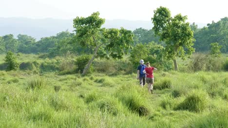 Couple-walking-in-rainforest-park-in-Chitwan,-Nepal.