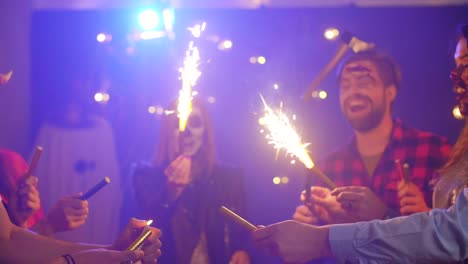 Friends-having-fun-with-sparkler-at-halloween-party