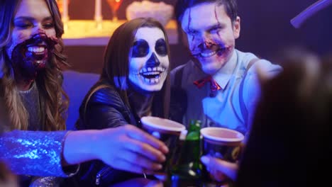 Gruppe-von-Freunden-in-Kostümen-Toasten-auf-der-Halloween-party