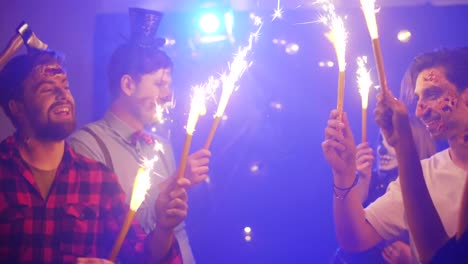 Crazy-friends-with-sparkler-dancing-at-the-halloween-party