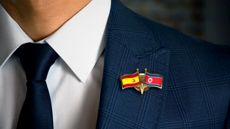 Geschäftsmann-zu-Fuß-in-Richtung-Kamera-mit-Freund-Country-Flags-Pin-Spanien---Nordkorea