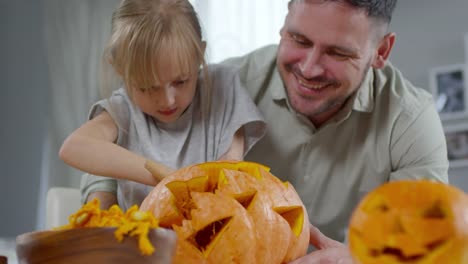 Kleines-Mädchen-macht-Jack-o-Laterne-mit-Papa