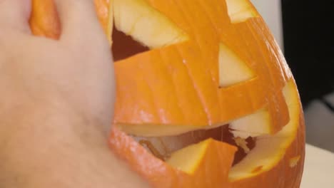 Man-Inspects-the-Face-of-a-Halloween-Jack-'O'-Lantern