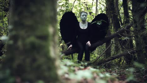 4k-Flügel-Halloween-Dark-Angel-Frau-mit-schwarz-im-Wald-schaut-sich-um