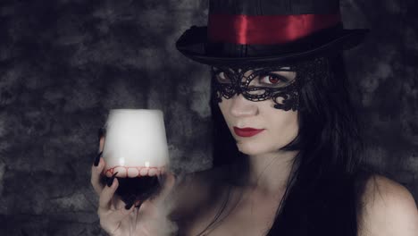 4k-Halloween-Shot-of-a-Witch-Holding-a-Glass-with-Smoke-and-Poison