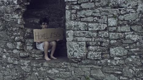 4k-Horror-Shot-of-an-Abandoned-Child-Holding-"Homeless"-on-cardboard