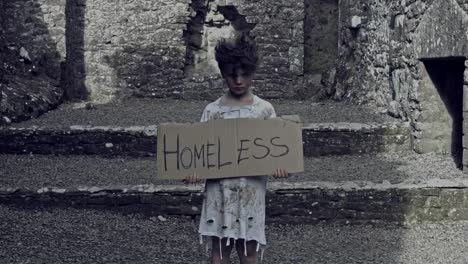 4k-Horror-Shot-of-an-Abandoned-Child-Holding-"Homeless"-on-cardboard