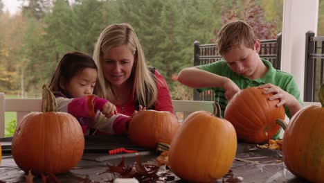 Mom-and-kids-carving-pumpkins-for-Halloween