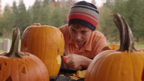 Kleiner-Junge-Kürbis-für-Halloween-schnitzen