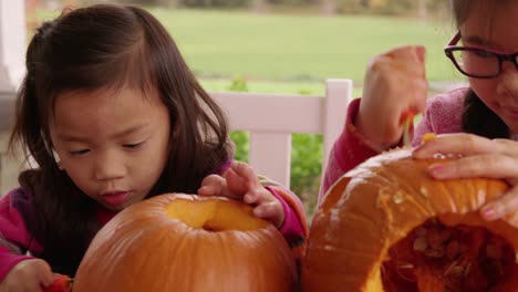 Young-girls-carving-pumpkin-for-Halloween