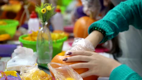 Konzept-der-familiären-Beziehungen.-Eltern-und-Kinder-Halloween-Feier-vorbereiten.-Schnitzen-Sie-und-dekorieren-Sie-Kürbisse-zusammen.-Kürbis-als-Herbst-Symbol-für-Halloween,-Thanksgiving,-Ernte-Parteien-und-Pumpkin-Spice-von-latte