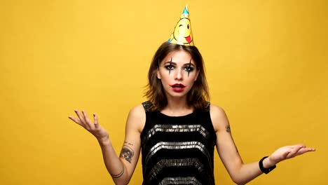 Displeased-strange-woman-with-holiday-cap-smiling-and-throwing-gift-isolated-over-yellow