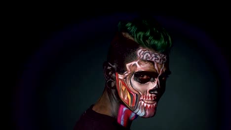 Man-with-bright-skull-make-up,-laughing-on-black-background