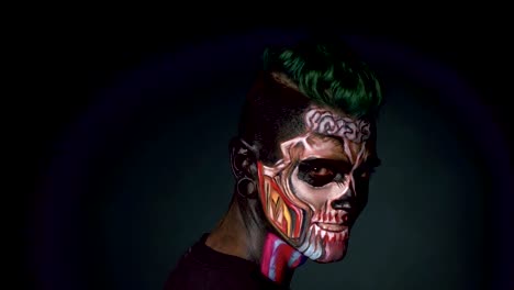 Hombre-con-calavera-brillante-maquillaje,-riendo-sobre-fondo-negro