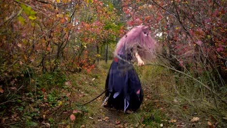 Bruja-joven-de-cabello-rosado-me-persigue-en-el-místico-bosque-de-otoño.-Halloween-está-llegando.