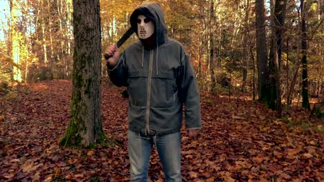 Man-with-scary-Halloween-mask-and-machete-walking-in-the-park