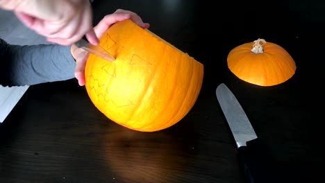 Female-hands-are-carving-a-Halloween-pumpkin