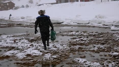 Fischer-geht-mit-einem-kompletten-Netz-von-Meeresfrüchten-ist-an-der-Küste-im-Winter