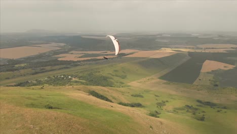 Atleta-paraglider-vuela-en-su-parapente-junto-a-las-golondrinas.-Seguimiento-desde-los-aviones-no-tripulados