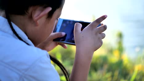 Little-boy-7-years-old-watching-video-or-playing-games-on-their-smart-phones.-happy,fun.-4K-Video