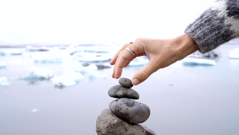 Detail-of-person-stacking-rocks-by-the-glacier-lagoon-in-Iceland