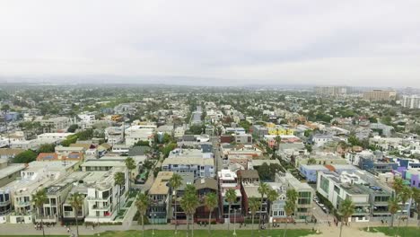 Vista-aérea-alejándose-del-barrio-hacia-el-océano-en-California