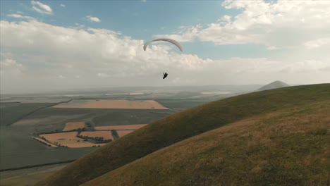 Atleta-paraglider-vuela-en-su-parapente-junto-a-las-golondrinas.-Seguimiento-desde-los-aviones-no-tripulados