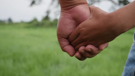 Close-up-hand-of-the-father-holding-the-daughter-hand-in-slow-motion-scene