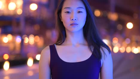 Portrait-Of-Beautiful-Asian-Woman-Smiling-Outdoors-At-Night