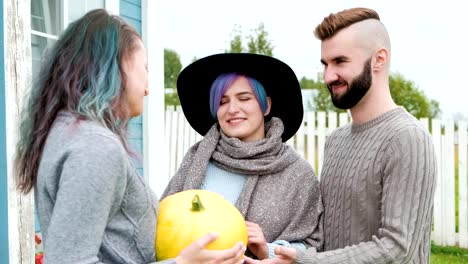 Three-people-in-background-of-village-house-on-farm-talk-and-laugh.