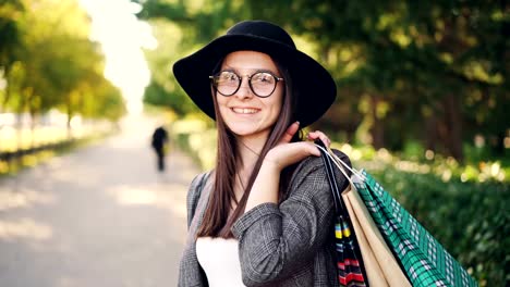 Retrato-de-shopper-alegre-chica-posando-con-bolsas-de-papel,-mirando-a-cámara,-sonriendo-y-riendo-de-pie-en-la-calle-de-la-gran-ciudad.-Juventud-y-concepto-comercial.