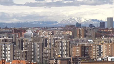 Cloudy-day-over-Madrid,-background-snowy-mountain