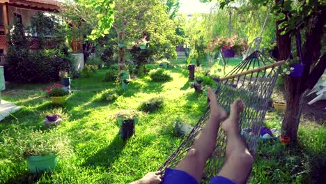 A-man-swinging-in-a-hammock-pov