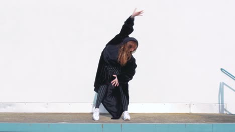 Young-Woman-Wearing-a-Large-Black-Winter-Coat-Dancing