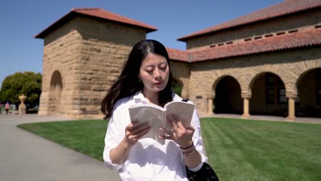 Student,-ein-Buch-zu-lesen,-während-des-Gehens-auf-dem-Platz