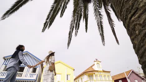 Couple-kissing-near-buildings-and-palm