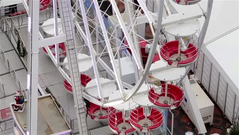 Close-Up-of-Ferris-Wheel-Cars-Spinning-Among-Christmas-Attractions-and-Lights