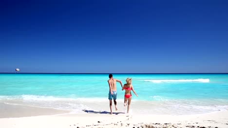 Junges-Paar-laufen-auf-das-Meer-am-Strand