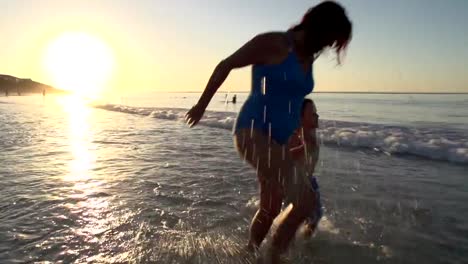 Mutter-und-Kind-spielen-am-Strand-auf-silhouette-bei-Sonnenuntergang,-Cape-Town