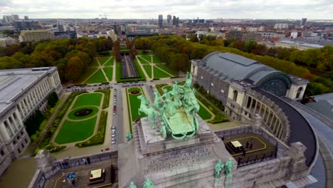 Horse-monument-in-Brussels-park,-city-view,-cars-tunnel-aerial.-Beautiful-aerial-shot-above-Europe,-culture-and-landscapes,-camera-pan-dolly-in-the-air.-Drone-flying-above-European-land.-Traveling-sightseeing,-tourist-views-of-Belgium.