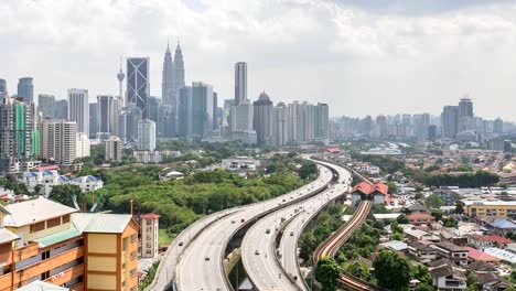 Time-lapse-hd-footage-of-road-lead-to-Kuala-Lumpur-city-center.-Showing-moving-cars-and-moving-clouds-during-daylight.-Zoom-out.