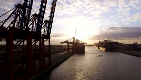 Hamburg-container-port-with-ships-and-cranes-at-sunset