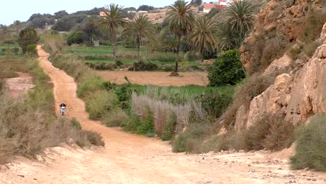 Mann-auf-einem-Motorrad-auf-Feldweg-in-Afrika