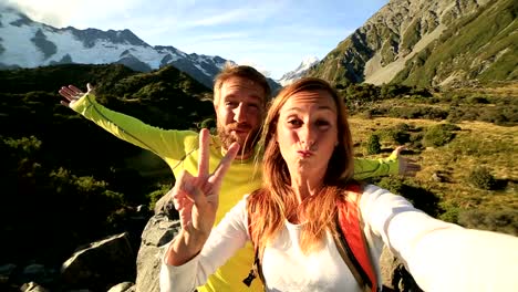 Young-couple-take-self-portrait-on-mountain-background