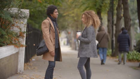 Stylish-Young-Couple-Talking-On-Fall-Street-In-City