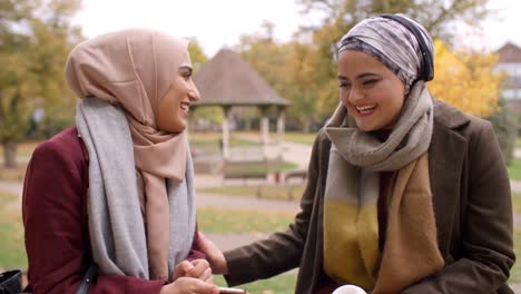 Encuentro-de-dos-mujeres-musulmanas-británicas-en-parque-urbano