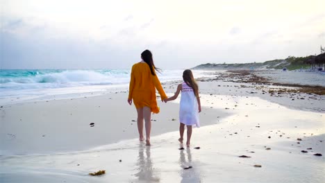 Entzückende-Mädchen-und-junge-Mutter-am-tropischen-Strand-in-warmen-Abend