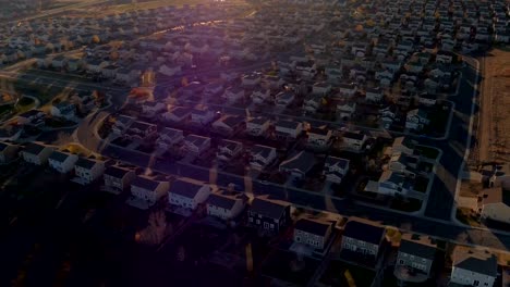 ANTENA:-Nuevas-casas-en-la-comunidad-suburbana-moderna-al-amanecer-soleado-en-Denver,-Estados-Unidos